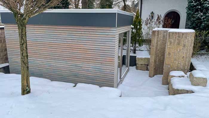 Der Eingang zum Saunahaus und die Öffnung der steinernen Duschmuschel.