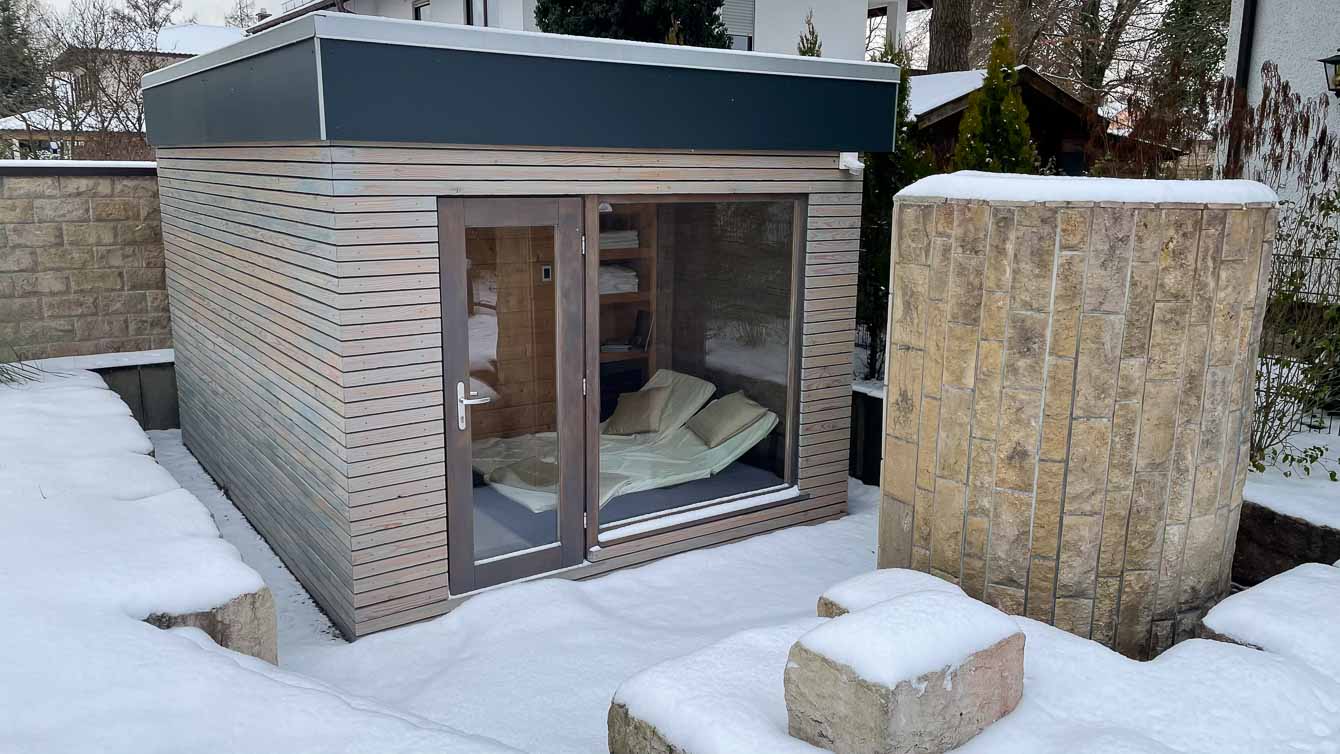 Zwei Stufen führen zum tiefer gelegenen Eingangsbereich des Saunahauses hinab.