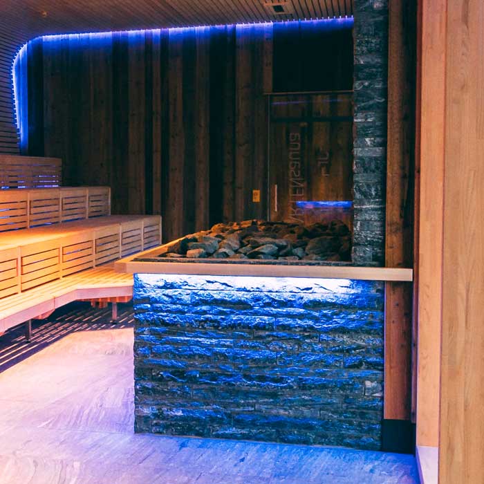 In Naturstein-Optik verkleideter Saunaofen-Bereich