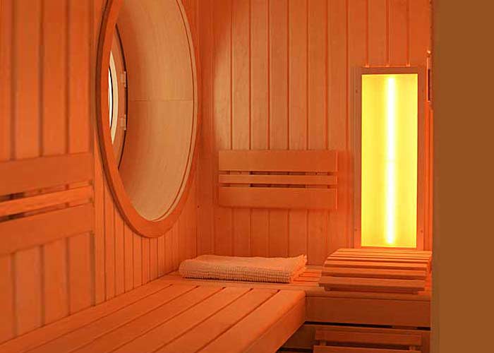 Handwerklich anspruchsvoll: Innensauna aus Espenholz mit kreisrundem Fenster